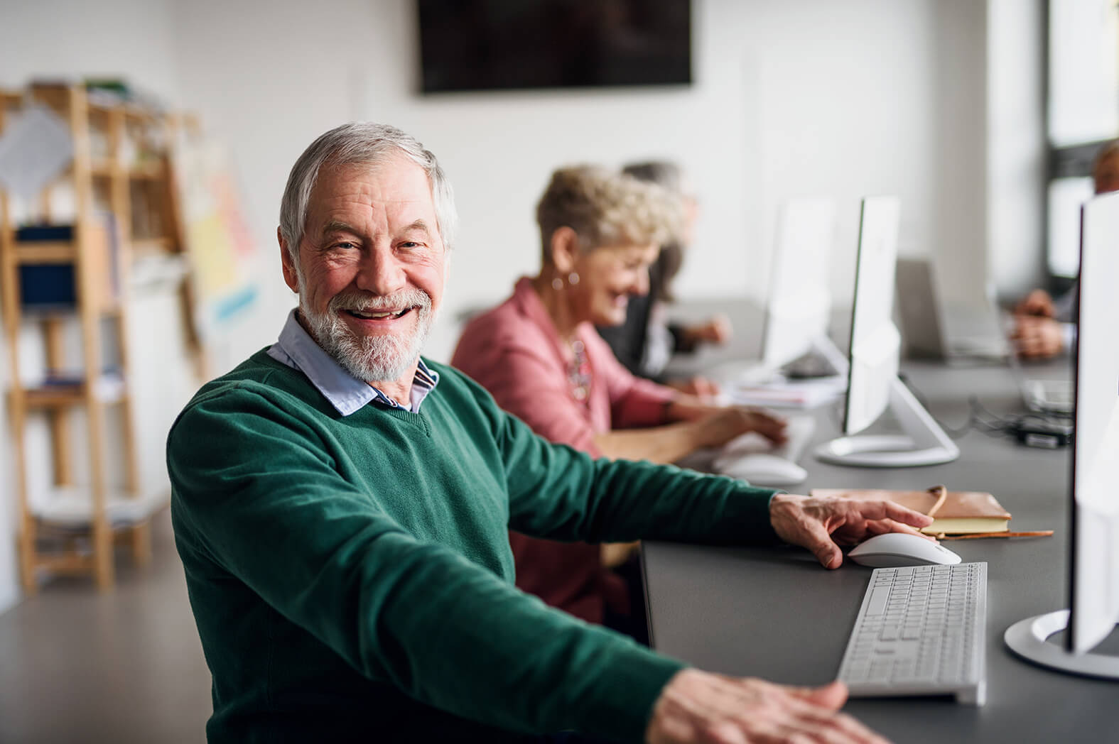 Älterer Mann besucht Computerkurs an der Volkshochschule