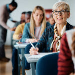 Erwachsene Schülerin macht sich im Kurs Notizen