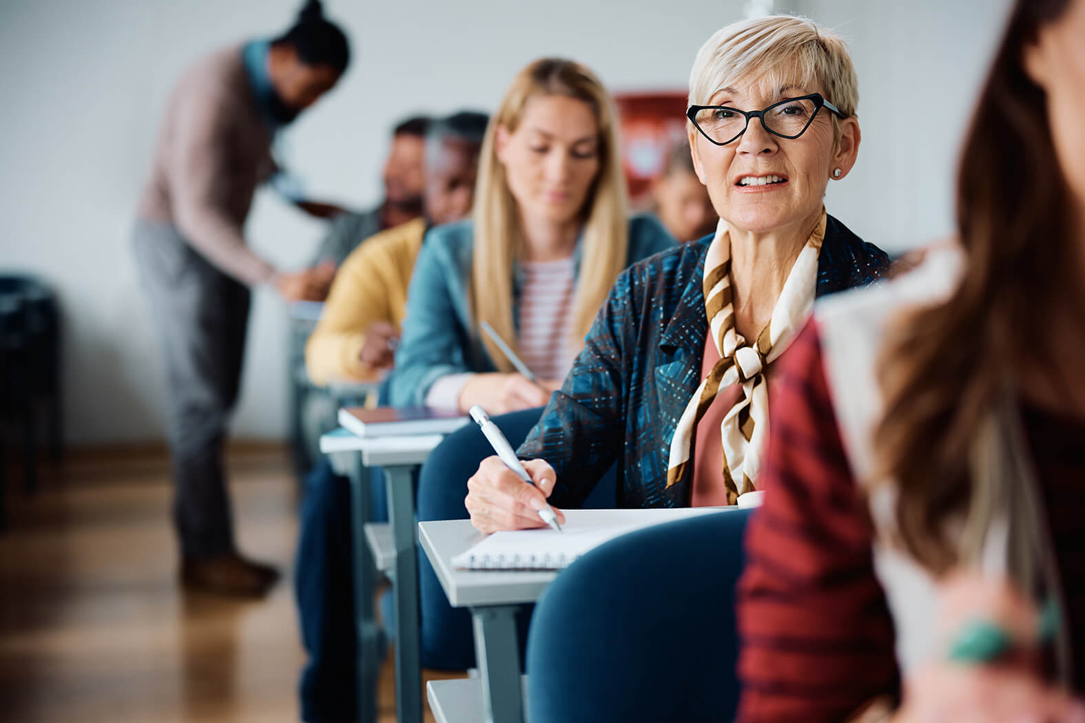 Erwachsene Schülerin macht sich im Kurs Notizen