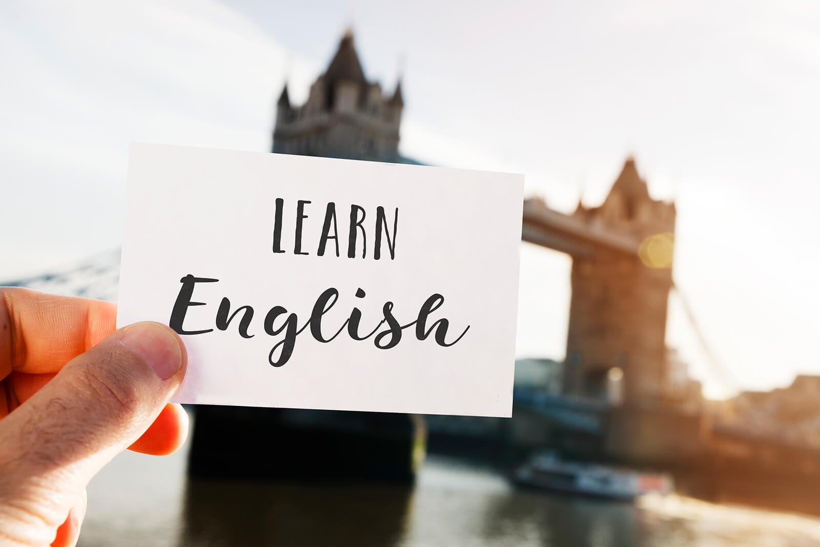 Person hält ein Schild vor die Tower Bridge auf Sprachreise in England